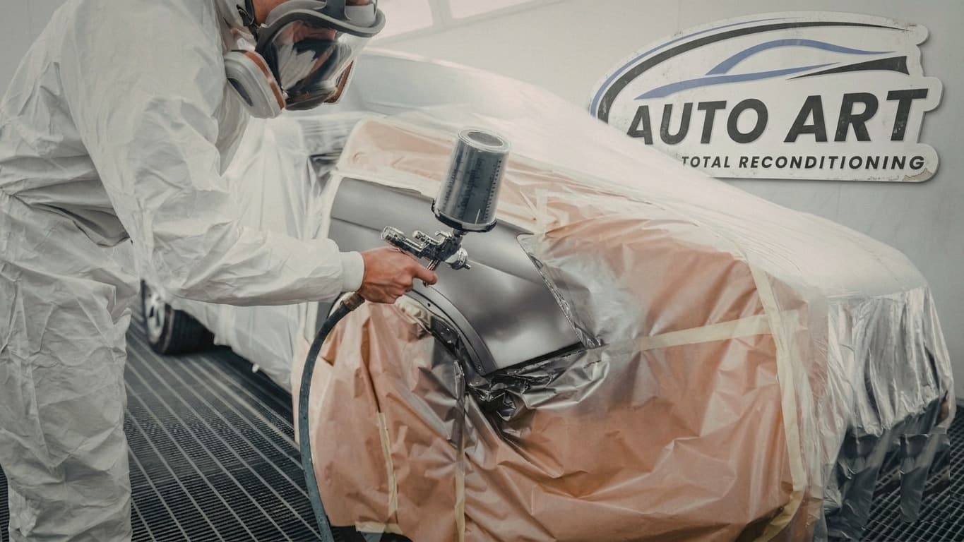 Auto Art paint and body technician in spray suit working inside the Austin TX paint booth