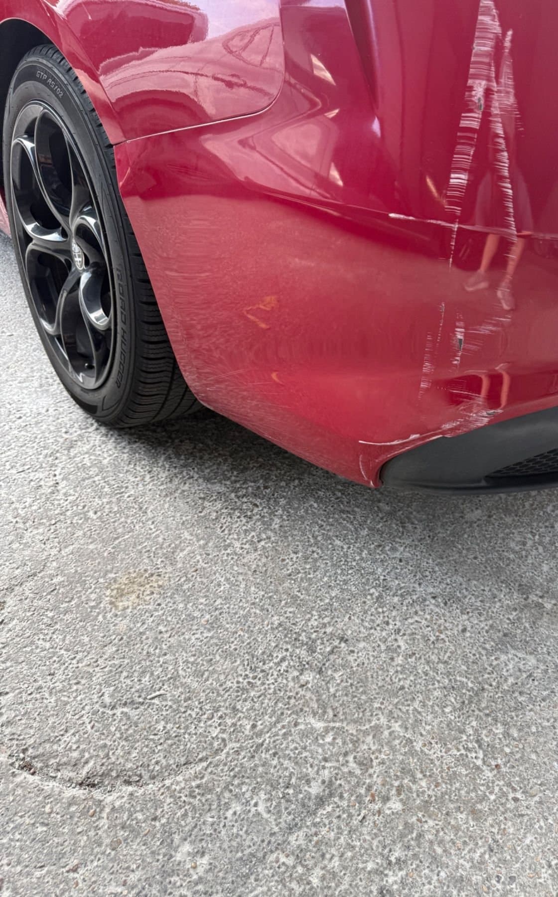 Before bumper scratch repair — scuffed red bumper in Austin, TX